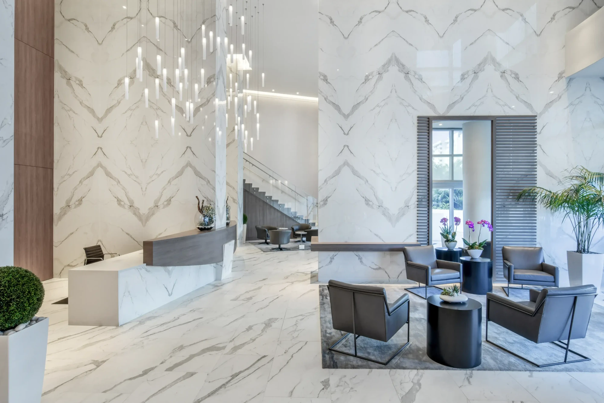 Reception desk and lounge at the Diplomat Residences in Hollywood, Florida, under a cascading linear light installation